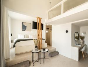 a bedroom with a bed and a living room at Rocabella Santorini Hotel & Spa in Imerovigli