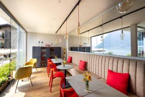 ColonnoにあるVilla Clementina Boutique Hotelのテーブルと赤い椅子、窓のあるレストラン