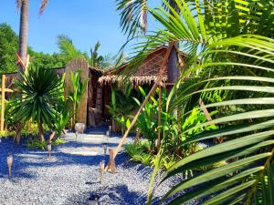 a house with a straw roof and some palm trees at 2BR 2Bath Eco Home Bungalow, Bangrak Beach, Koh Samui in Amphoe Koh Samui