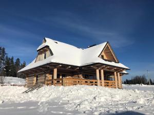 una baita di tronchi con tetto ricoperto di neve di Znak Gór a Czorsztyn