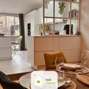 a kitchen with a table with wine glasses on it at H3 Charmante maison sur la Vilaine près du Château in Vitré