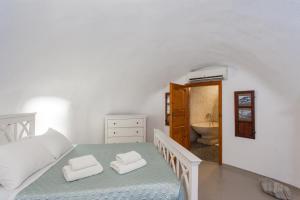 a white bedroom with a bed and a bathroom at Cavern House Anthea in Éxo Goniá +43 photos