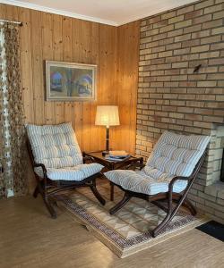 two chairs and a table in a room with a brick wall at Brekkesten by Norgesbooking - cabin in Stavern in Stavern