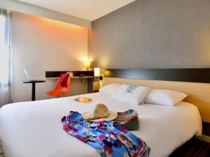 una habitación de hotel con una cama con sombrero en Kyriad Tours Sud - Chambray Lès Tours, en Chambray-lès-Tours
