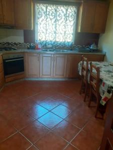 a kitchen with a tile floor and a window at Os Girassóis da Carla in Braga +5 photos