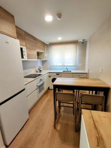 a kitchen with a table and a white refrigerator at VuT QUINTA LA LEGUA in Quintanadueñas