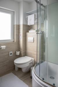 a bathroom with a toilet and a glass shower at Tündérfátyol in Abádszalók +22 photos
