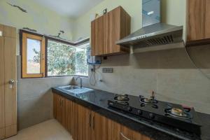 Il comprend une cuisine équipée d'une cuisinière et d'un évier. dans l'établissement Pet-Friendly mountain view 2 bedroom cottage C1, à Mukteswar