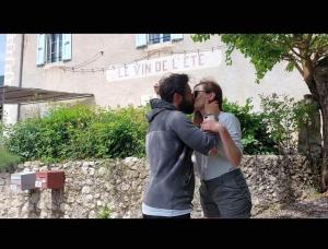 two men are kissing in front of a building at Le Vin de l'Eté in Ponet-et-Saint-Auban