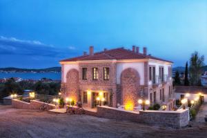 a large brick house with lights on it at night at Cunda Fora Hotel in Ayvalık