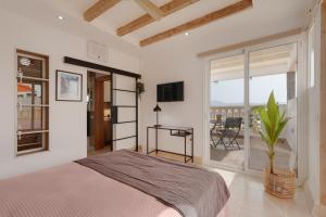 a white bedroom with a bed and a balcony at Las Arenas Family in Costa Calma