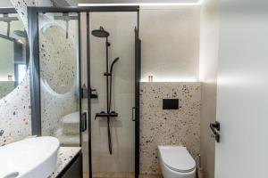 a bathroom with a shower and a toilet at Athena & Phevos - Seaside View Luxury Suite in Nea Makri