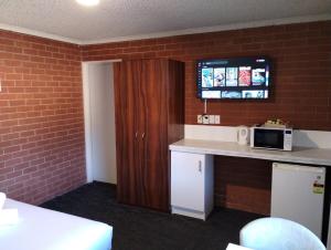 a small kitchen with a counter and a microwave at Junction Motel Wagga in Wagga Wagga