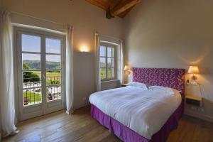 a bedroom with a large bed and a large window at Cascina Alberta in Treiso