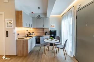 a kitchen and dining room with a table and chairs at Athena & Phevos - Seaside View Luxury Suite in Nea Makri