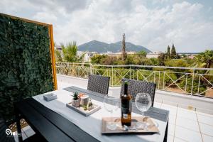 a table with a bottle of wine on a balcony at Athena & Phevos - Seaside View Luxury Suite in Nea Makri