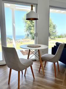 a table and chairs in a living room with a view of the ocean at Bungalow for 2 - Dream Oasis Dobra Voda in Dobra Voda