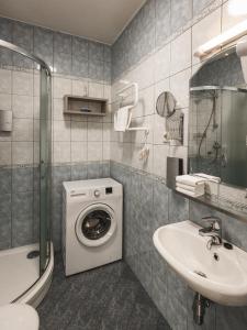 Un baño con lavadora y lavabo. en Bearsleys Downtown Apartments, en Riga 116 fotos más