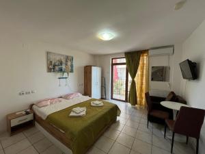 a bedroom with a bed and a table and a television at Garsoniere Victor Seaview Aer Conditionat- Bucatarie-Primim Carduri Vacanta-Pet Friendly la 3 minute de Plaja Reyna-Zoom Beach in Constanţa