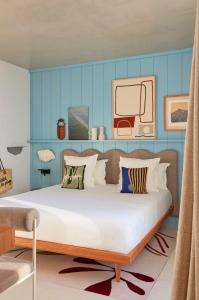 a bedroom with a large bed with blue walls at Hôtel de La Plage in Biarritz