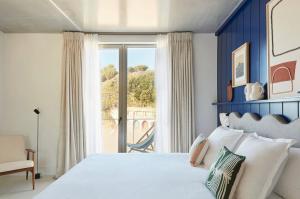 a bedroom with a bed and a large window at Hôtel de La Plage in Biarritz