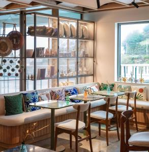 a restaurant with tables and a bench and windows at Hôtel de La Plage in Biarritz
