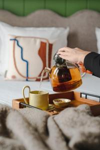 a person pouring coffee into a cup on a table at Hôtel de La Plage in Biarritz