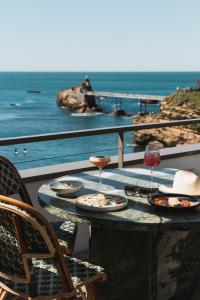 a table with plates of food and glasses of wine at Hôtel de La Plage in Biarritz