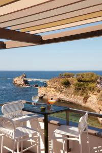 a table and chairs on a balcony with a view of the ocean at Hôtel de La Plage in Biarritz