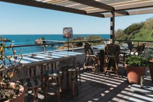 a patio with chairs and a table and the ocean at Hôtel de La Plage in Biarritz