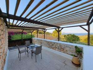a patio with a wooden pergola and a table and chairs at Tsivouli Accommodation in Lithakia