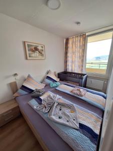 two twin beds in a room with a window at App 342 gemütlich und mit Weitblick in Braunlage