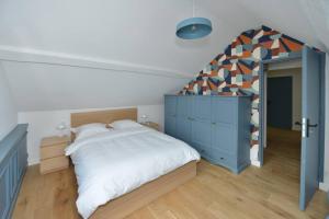 a bedroom with a large bed and a blue cabinet at Maison entièrement rénové de 4 pièces in Nogent-le-Roi