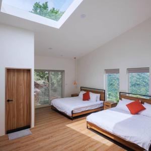 ein Schlafzimmer mit zwei Betten und einem Dachfenster in der Unterkunft Kilar Mountain Villa in Zeren