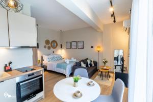 un piccolo soggiorno con letto e tavolo di Phevos & Athena Luxury Suite With View In Nea Makri a Nea Makri