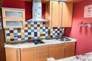 a kitchen with a sink and a red wall at Acogedor loft con vistas a la ciudad in Santander +43 photos