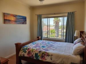 a bedroom with a bed and a window with a view at Beach side holiday apartment in Port Adelaide +4 photos
