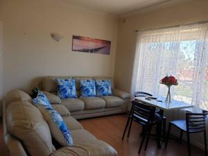 a living room with a couch and a table at Beach side holiday apartment in Port Adelaide