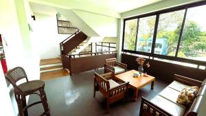 a room with a table and chairs and a staircase at Rockstar Beach Apartments in Bang Rak Beach