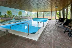 a large swimming pool in a room with chairs at Stössels Hotel in Altenmedingen