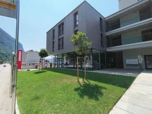 a building with two trees in front of it at LabPark enjoy Melano in Melano