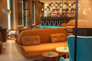 een lobby met een bank, tafels en een bar bij Motel One Berlin-Potsdamer Platz in Berlijn