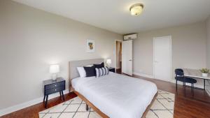 a bedroom with a white bed and a desk and a bed sidx sidx sidx sidx at Avenue A810 Epic 2br, Pool, Gym, Parking in Philadelphia +12 photos