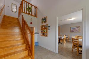 a hallway with stairs and a dining room with a table at Auberge Doucet Inn in Chéticamp