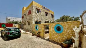 a car parked in front of a stone building at Beach House with Sea Views and Rooftop Terrace in Sidi Kaouki