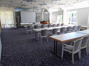 a conference room with tables and chairs and a whiteboard at Hotel Aichtaler Hof in Grötzingen