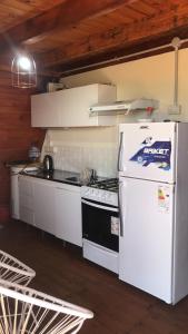 a kitchen with a white refrigerator and a stove at Cabañas Hakuna Matata in San Blás