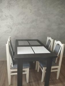 a black table and chairs in a room at Mini Apartament Sosnowa in Krasnobród +2 photos
