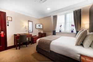 a hotel room with a bed and a desk at Gem Fitzrovia Hotel in London