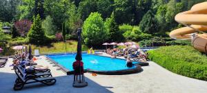 カルパチにあるVacationClub - Alpina, Wita Stwosza 8 Apartament 1のラウンジチェアに座る人々と大きなスイミングプール +7枚の写真